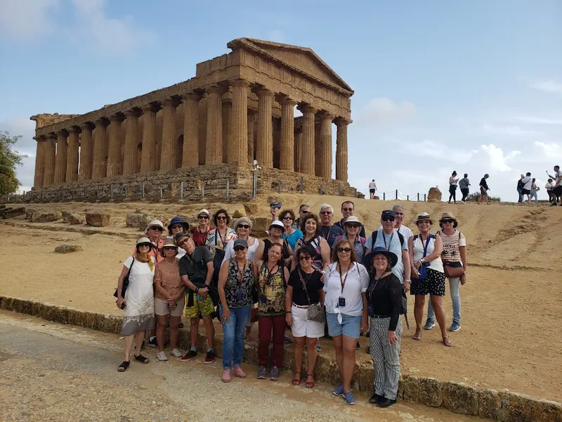 Grupo de viajantes da Cenci reunido diante de um templo antigo